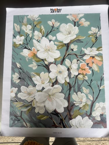 Customer's completed Spring Blossom Tapestry paint-by-numbers canvas, showing white flowers on a green background.