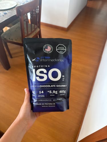 Cliente sosteniendo el empaque negro de Proteína Aislada ISO sabor chocolate en una mano.