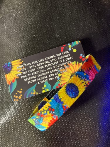 Customer's colorful Bloom Anyway Bracelet with a sunflower pattern, shown with its themed backing card.