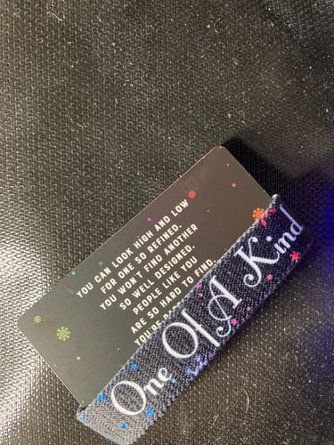 Close-up of a customer's 'One Of A Kind' bracelet with colorful snowflake details, displayed on its matching card.