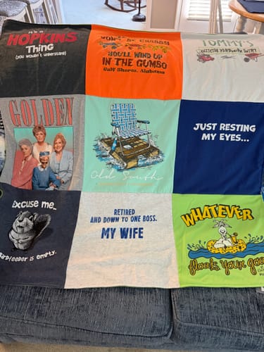 Customer's Project Repat T-Shirt Quilt with assorted humorous and graphic t-shirts, shown draped over a couch.