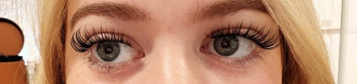 Rezensentin zeigt eine Nahaufnahme ihrer Augen, die die langen Pink Wink Wimpern im Cateye-Stil tragen.