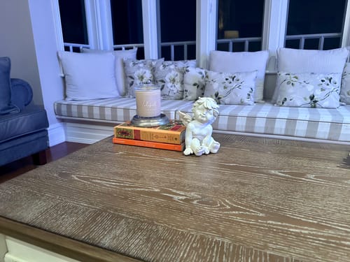 Customer's white cherub figurine styled on a wooden coffee table next to books and a candle.