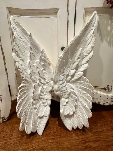 Close-up of a customer's Alora Angel Wings, showing the detailed distressed white finish.