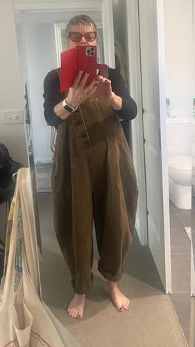 Reviewer wearing the baggy brown jumpsuit with rolled cuffs indoors.