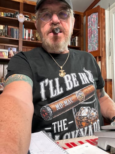 Reviewer wearing his personalized black "I’ll Be In The Backyard" shirt with a cigar and whiskey graphic.