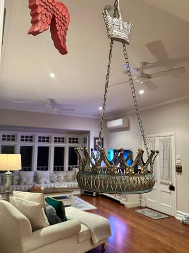 Customer's empty Johanna Crown Hanging Planter with an aged metal finish hanging from a ceiling indoors.