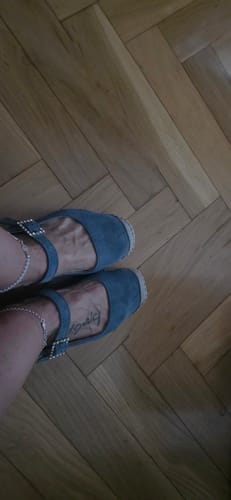Una clienta lleva puestas las Alpargatas Susana Azul, mostrando una vista cenital del calzado sobre un suelo de madera.