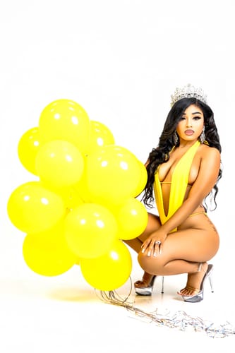 Customer crouching in the yellow Zuri One Piece swimsuit, showing the suit's plunging neckline.