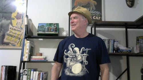 A customer smiles while wearing the navy blue Octopus Drummer T-Shirt.