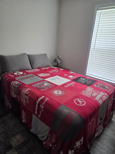 Customer's red Project Repat T-Shirt Quilt featuring Alabama t-shirts spread neatly on a bed.