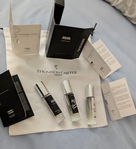 Customer's collection of Thomson Carter perfume samples, with packaging for Shelby Lane, on a branded cloth bag.