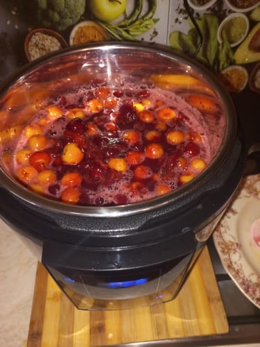 Customer making cherry jam in the Multicooker Novio SteelCook, with the stainless steel pot full of bubbling fruit.