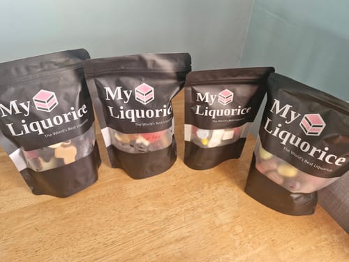 Customer's four black pouches from the Discovery Liquorice Bundle showing the variety of liquorice inside.