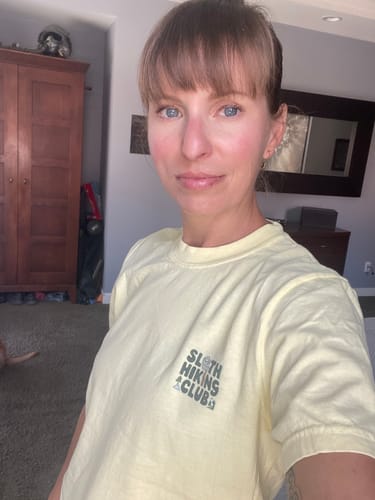 Reviewer wearing a small, yellow SlothHikingClub T-Shirt to show the fit.