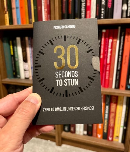 Customer holding the black packaging for the '30 Seconds to Stun' magic trick with gold lettering.