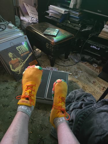 Customer's point-of-view of their bright yellow Smart II - Barefoot Shoes with orange laces.