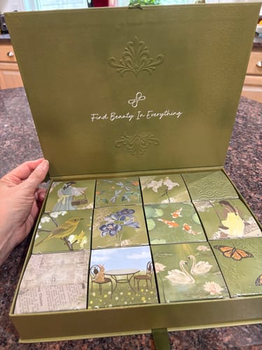 Customer holding open the olive green 12 pcs Spring Box Packaging, showing the 12 decorative boxes inside.