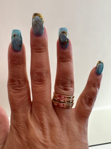 A reviewer wearing the gold-plated Fidget Ring on their ring finger.