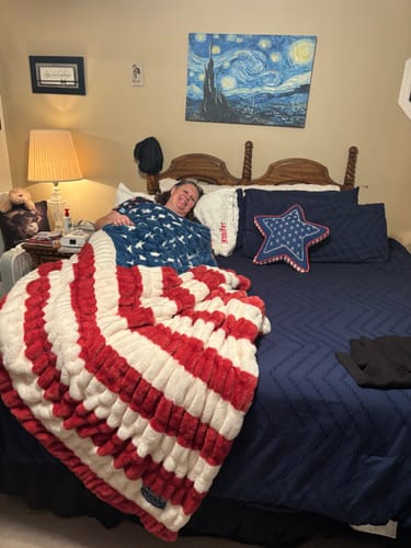 Customer smiling in bed next to their white, personalized Sorbet Pillowcase.