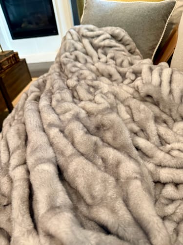 Customer's soft, plush Hugs Chai Blanket draped over a chair, showing its texture.