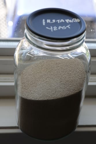 Customer's Chalkboard Top Mason Jar Lids on a glass jar filled with yeast, labeled in white.
