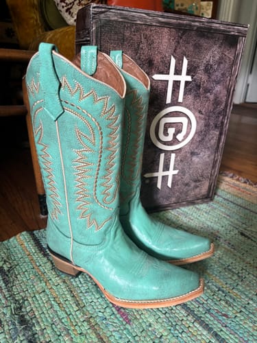 Customer's turquoise Circle G western boots with intricate embroidery, standing next to their original brand box.