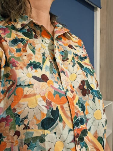 Customer's artsy flower print shirt worn with a turn-down collar, showcasing the vibrant colorful pattern.