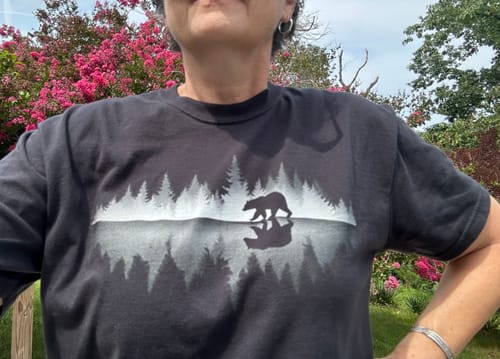 Customer's Bear Reflection T-Shirt in black, showing a graphic of a bear with a mirror forest reflection