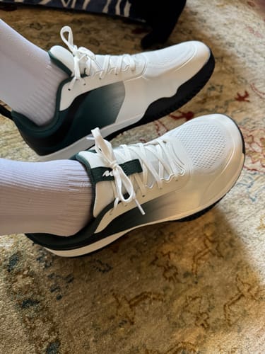 Customer's feet wearing white CUURT Muuv court shoes with white socks.