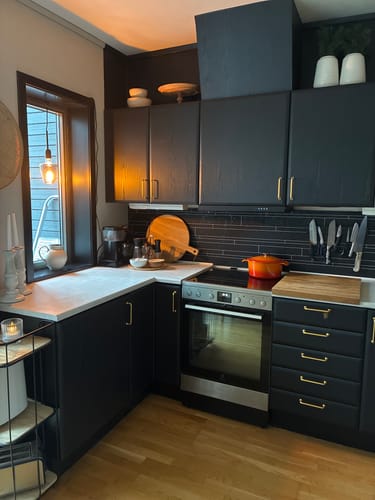 Customer's Treverk sort matt kontaktplast applied to kitchen cabinets, giving a dark and modern look.