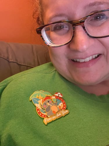 Customer's Fun in the Sun Pin featuring a cartoon bird, pinned to a bright green shirt.