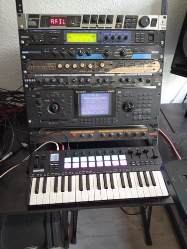 Customer's Donner Starrykey-37 MIDI Controller placed on a desk in front of a rack of musical studio equipment.