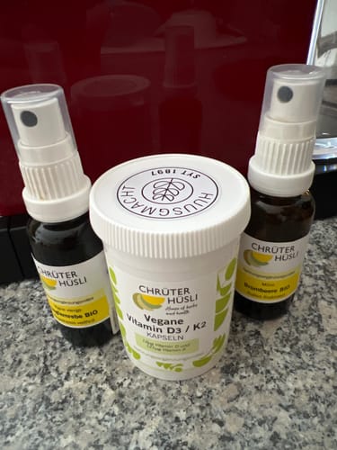 Customer's Vegane Vitamin D3 / K2 Kapseln container next to two spray bottles from Chrüterhüsli.