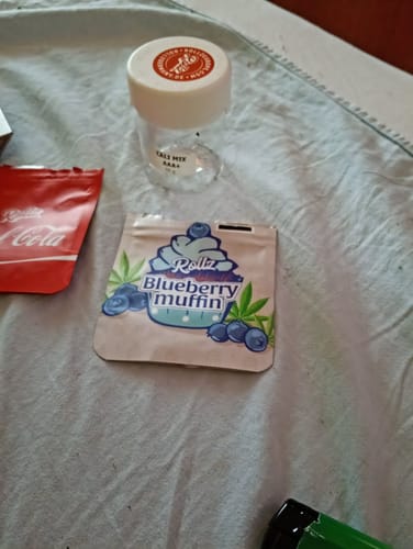 Customer's Rollz Blueberry Muffin product packaging next to an empty jar on a white cloth surface.