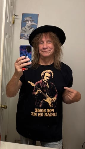 Customer wearing the black Poe Some Sugar On Me T-shirt, pointing to the Edgar Allan Poe graphic while holding a phone.