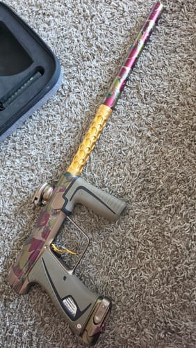 Customer's Infamous Deuce 1R DNA Trigger installed on a patterned paintball marker with gold accents.