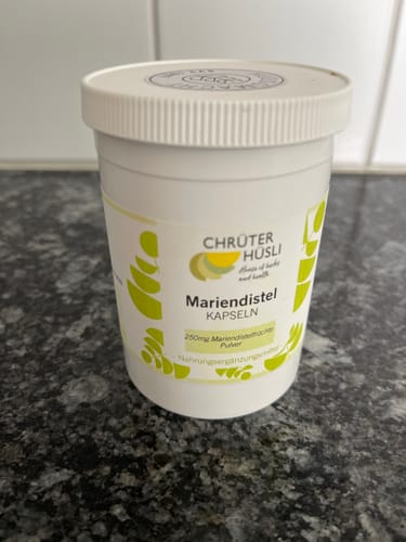 Kunden-Foto der Mariendistel Kapseln Dose von Chrüterhüsli auf einer dunklen Arbeitsplatte.