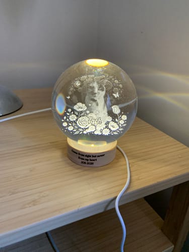 Customer's glowing Personalized Crystal Ball LED Night Light featuring an etched pet portrait on a wooden base.