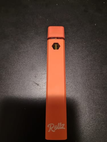 Customer's orange Rollz THC-A vape device, seen in a close-up shot.