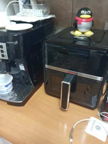 Reviewer's black Air Fryer Novio StonePro sitting on a kitchen counter next to a coffee machine.