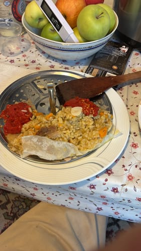 Customer's set of 100 hartii de copt, with one liner visible inside the air fryer basket under cooked food