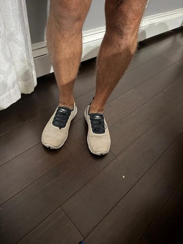 Customer's light-colored Men's Xdrain Crew shoes being worn indoors on a dark wood floor.