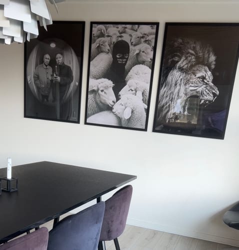 Customer's three framed Built Different art prints displayed on a white wall above a black dining table.