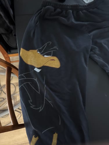 Customer's Looney Tunes Character Sweats in black featuring oversized gold Daffy Duck artwork on the leg