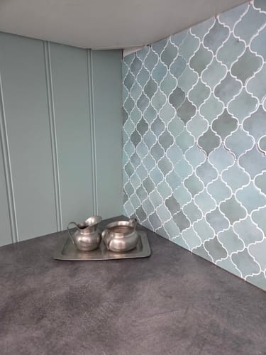 Customer's Lanterne grønn veggfliser montert som kjøkken-backsplash med to metallkanner på benken.