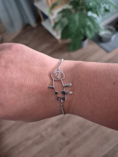Customer's Persönliche Kinderzeichnung Halskette als Armband mit silberfarbenem Anhänger eines gezeichneten Tieres am Handgelenk.