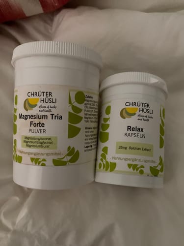 Kundenfoto der RELAX KAPSELN CHRüTERHüSLI Kapseln neben einer Dose Magnesium Tria Forte Pulver auf einer weissen Decke.
