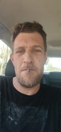 Customer's face as they use the White Truffle THC-A flower inside a car.