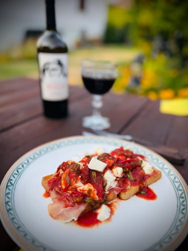 Reviewer's Paprika edelsüss Bio used as a vibrant red seasoning on a piece of toasted bread with cheese and ham.